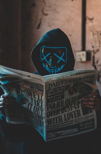Person med mask läser en tidning